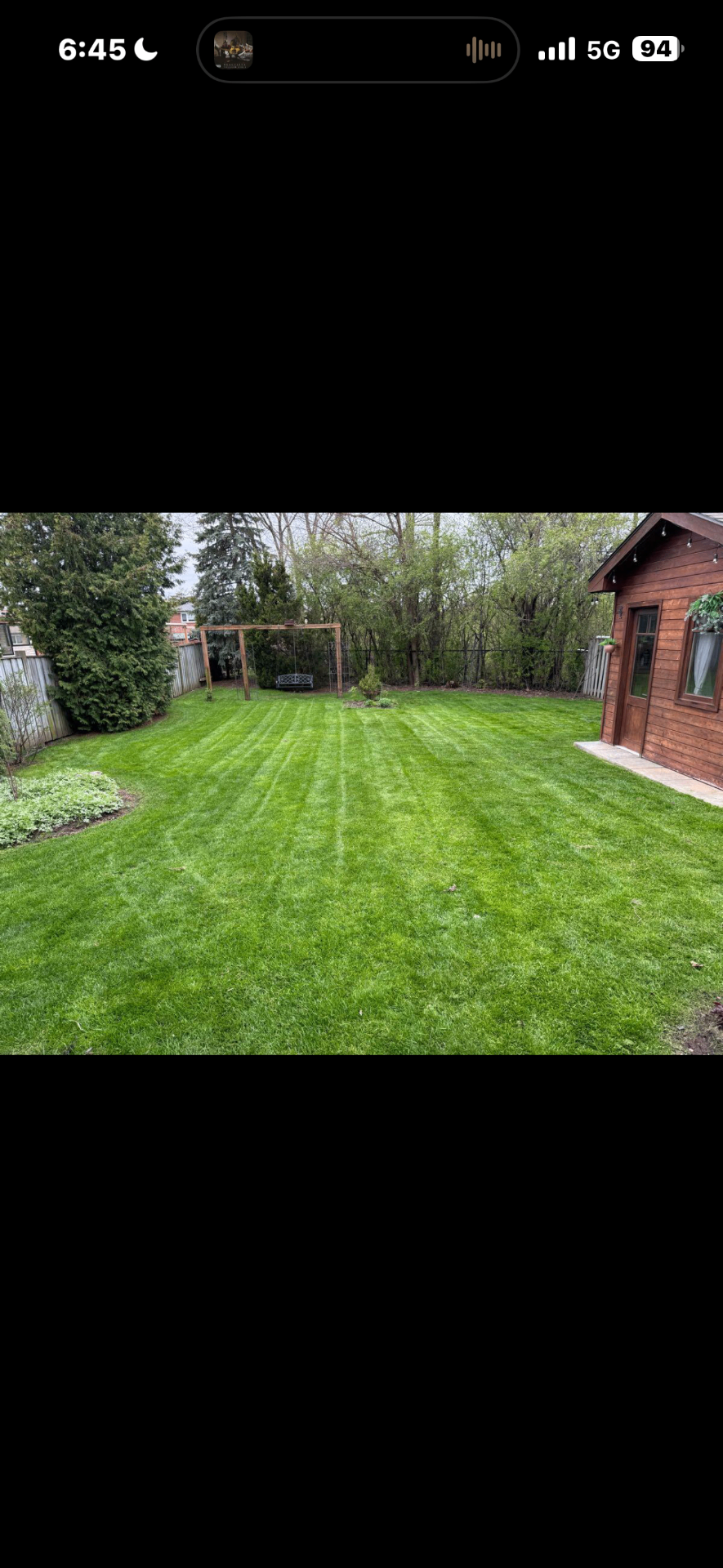 Backyard lawn with crisp mowing stripes maintained by Sonoma Yardworks